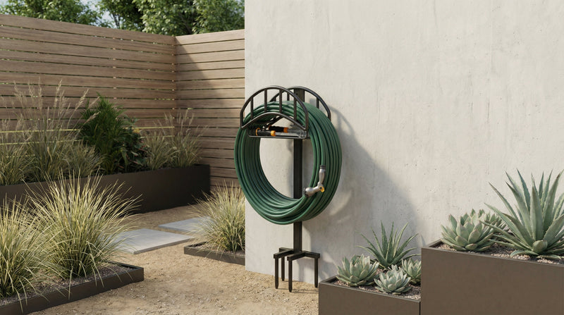 Minimalist garden hose storage stand with neatly coiled green hose, placed in a modern outdoor garden setting