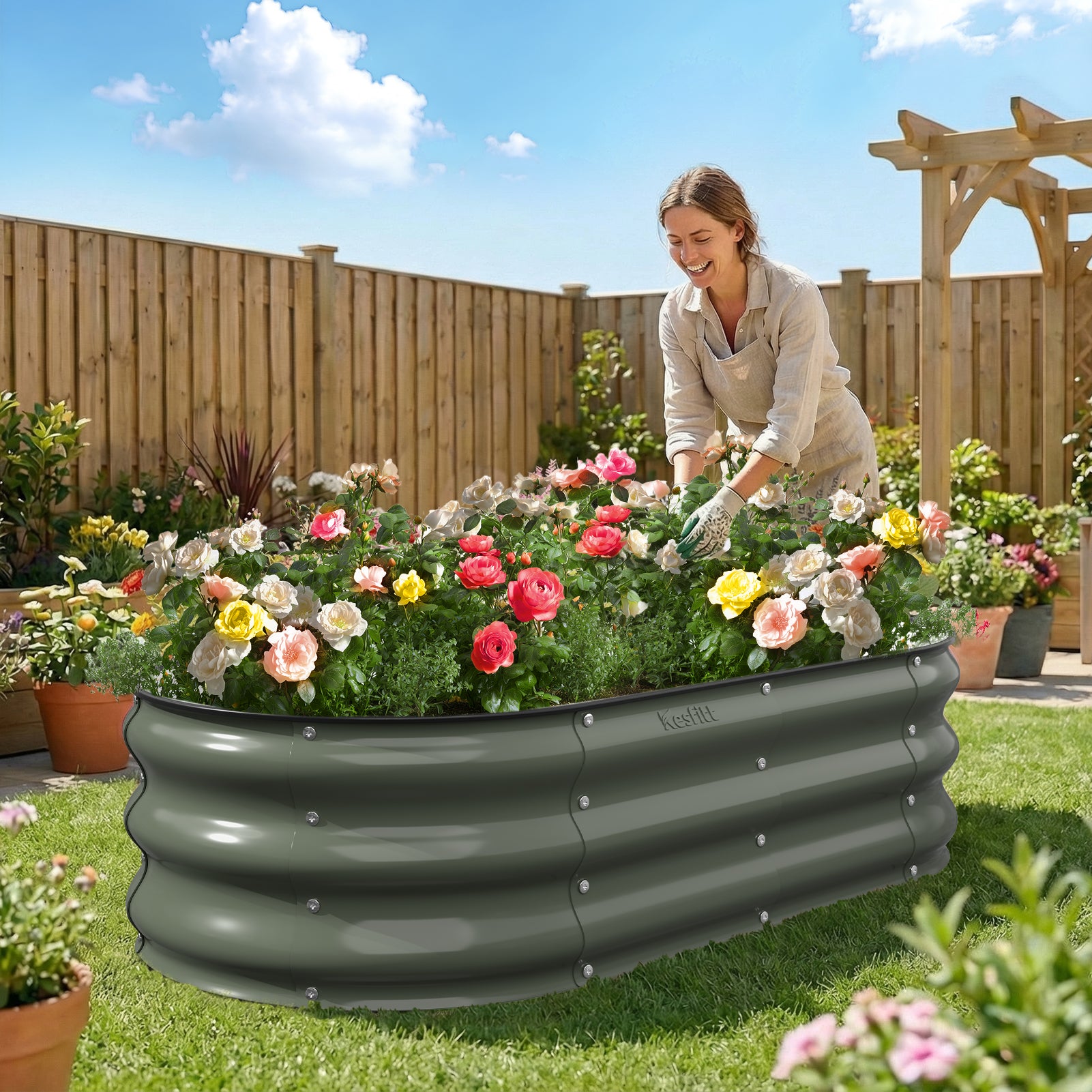 Woman tending to flowers in a large garden bed with a wooden fence and sky in the background